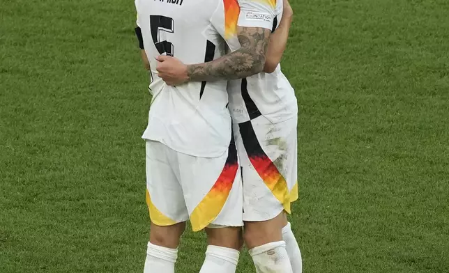 Germany's Toni Kroos, right, hugs Joshua Kimmich at the end of a quarter final match between Germany and Spain at the Euro 2024 soccer tournament in Stuttgart, Germany, Friday, July 5, 2024. Spain won the team 2-1. (AP Photo/Michael Probst)