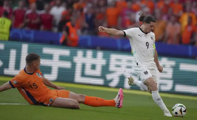 Austria's Marcel Sabitzer (9) scores a goal past Micky van de Ven of the Netherlands (15) during a Group D match at the Euro 2024 soccer tournament in Berlin, Germany, Tuesday, June 25, 2024. (AP Photo/Sunday Alamba)