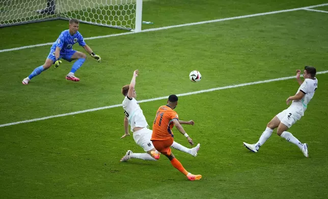 Cody Gakpo of the Netherlands, second right, scores his side's first goal during a Group D match between the Netherlands and Austria at the Euro 2024 soccer tournament in Berlin, Germany, Tuesday, June 25, 2024. (AP Photo/Petr David Josek)