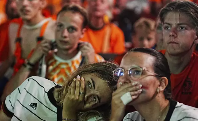 Netherlands soccer fans react at a pubic screening at the end of a semi final match between Netherlands and England at the Euro 2024 soccer tournament in Dortmund, Germany, Wednesday, July 10, 2024. (AP Photo/Markus Schreiber)