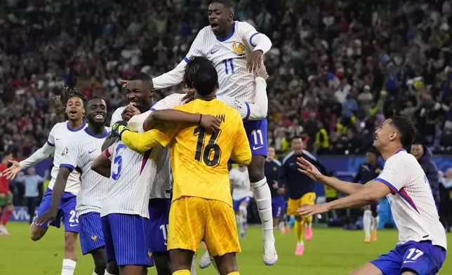 France players celebrate after penalty shootout against Portugal during a quarter final match at the Euro 2024 soccer tournament in Hamburg, Germany, Friday, July 5, 2024. (AP Photo/Hassan Ammar)