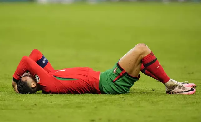 Portugal's Cristiano Ronaldo lies on the ground after being fouled by Theo Hernandez of France during a quarter final match at the Euro 2024 soccer tournament in Hamburg, Germany, Friday, July 5, 2024. (AP Photo/Hassan Ammar)