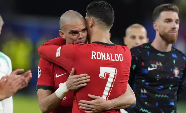 Portugal's Cristiano Ronaldo, right, embraces Pepe at the end of a quarter final match against France at the Euro 2024 soccer tournament in Hamburg, Germany, Friday, July 5, 2024. (AP Photo/Hassan Ammar)