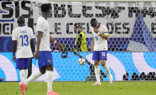 Kylian Mbappe of France, right, gestures during a quarter final match against Portugal the Euro 2024 soccer tournament in Hamburg, Germany, Friday, July 5, 2024. (AP Photo/Hassan Ammar)