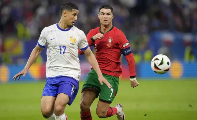 Portugal's Cristiano Ronaldo vies for the ball with William Saliba of France, left, during a quarter final match between Portugal and France at the Euro 2024 soccer tournament in Hamburg, Germany, Friday, July 5, 2024. (AP Photo/Martin Meissner)