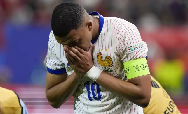 Kylian Mbappe of France reacts after an injury during a quarter final match between Portugal and France at the Euro 2024 soccer tournament in Hamburg, Germany, Friday, July 5, 2024. (AP Photo/Frank Augstein)