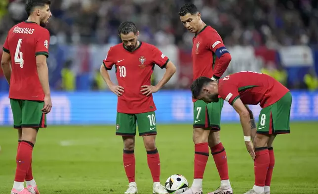 Portugal's Ruben Dias, Bernardo Silva, Cristiano Ronaldo and Bruno Fernandes, from left, prepare to take a free kick during a quarter final match between Portugal and France at the Euro 2024 soccer tournament in Hamburg, Germany, Friday, July 5, 2024. (AP Photo/Martin Meissner)