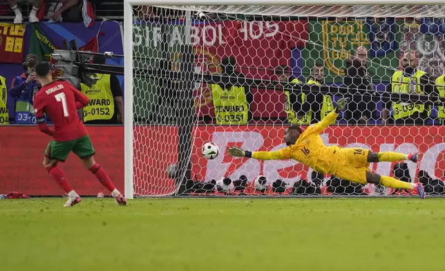 Portugal's Cristiano Ronaldo scores during the penalty shootout of a quarter final match between Portugal and France at the Euro 2024 soccer tournament in Hamburg, Germany, Friday, July 5, 2024. (AP Photo/Andreea Alexandru)