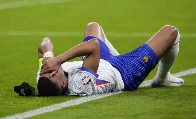 Kylian Mbappe of France reacts after an injury during a quarter final match between Portugal and France at the Euro 2024 soccer tournament in Hamburg, Germany, Friday, July 5, 2024. (AP Photo/Frank Augstein)