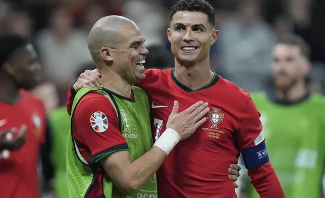 Portugal's Pepe, left, and Cristiano Ronaldo celebrate their win in penalties shootouts after a round of sixteen match between Portugal and Slovenia at the Euro 2024 soccer tournament in Frankfurt, Germany, Monday, July 1, 2024. (AP Photo/Matthias Schrader)