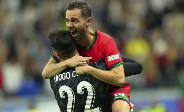 Portugal's goalkeeper Diogo Costa, left, and his teammate Bernardo Silva celebrate their win against Slovenia during a round of sixteen match between Portugal and Slovenia at the Euro 2024 soccer tournament in Frankfurt, Germany, Monday, July 1, 2024. (Spada/LaPresse via AP)