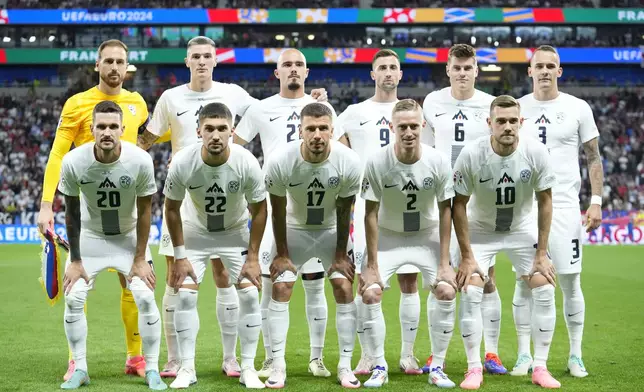 Slovenia starting players pose for a team photo at the beginning of a round of sixteen match between Portugal and Slovenia at the Euro 2024 soccer tournament in Frankfurt, Germany, Monday, July 1, 2024. (AP Photo/Ebrahim Noroozi)