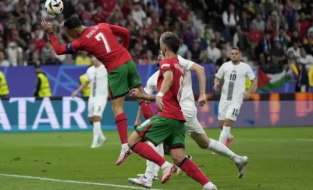Portugal's Cristiano Ronaldo heads the ball during a round of sixteen match between Portugal and Slovenia at the Euro 2024 soccer tournament in Frankfurt, Germany, Monday, July 1, 2024. (AP Photo/Matthias Schrader)