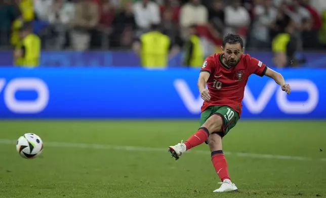 Portugal's Bernardo Silva scores in penalty shoot outs of a round of sixteen match between Portugal and Slovenia at the Euro 2024 soccer tournament in Frankfurt, Germany, Monday, July 1, 2024. (AP Photo/Matthias Schrader)