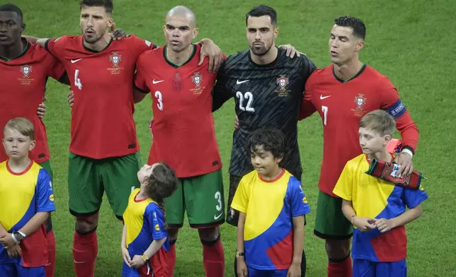 Portugal players sing their national anthem before a round of sixteen match between Portugal and Slovenia at the Euro 2024 soccer tournament in Frankfurt, Germany, Monday, July 1, 2024. (AP Photo/{Michael Probst)