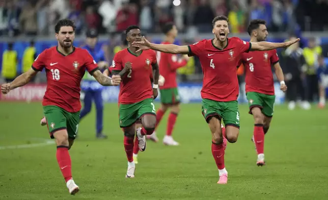 Portugal's players celebrate after winning the penalties shootouts of a round of sixteen match between Portugal and Slovenia at the Euro 2024 soccer tournament in Frankfurt, Germany, Monday, July 1, 2024. (AP Photo/Ariel Schalit)