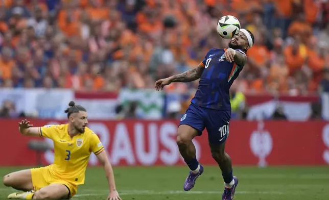 Memphis Depay of the Netherlands tries control the ball past Romania's Radu Dragusin during a round of sixteen match between Romania and the Netherlands at the Euro 2024 soccer tournament in Munich, Germany, Tuesday, July 2, 2024. (AP Photo/Matthias Schrader)