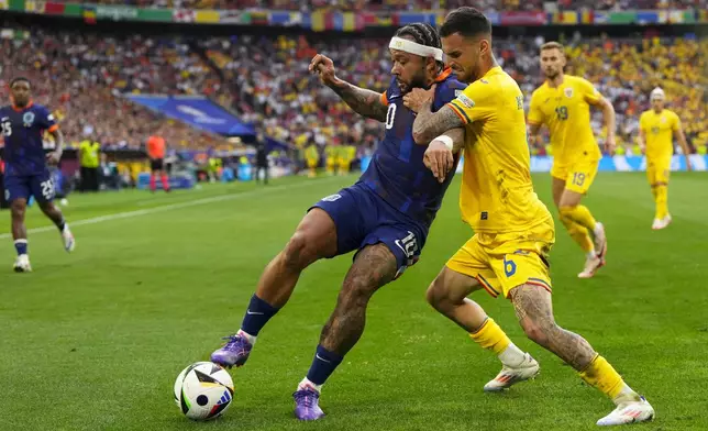 Romania's Marius Marin fights for the ball with Memphis Depay of the Netherlands, left, during a round of sixteen match between Romania and the Netherlands at the Euro 2024 soccer tournament in Munich, Germany, Tuesday, July 2, 2024. (AP Photo/Manu Fernandez)
