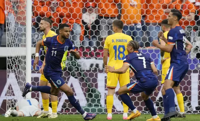 Netherlands' Cody Gakpo (11) celebrates with teammates after scoring the opening goal during a round of sixteen match between Romania and the Netherlands at the Euro 2024 soccer tournament in Munich, Germany, Tuesday, July 2, 2024. (AP Photo/Ariel Schalit)