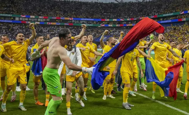 Romania's players celebrate at the end of the match during a Group E match between Slovakia and Romania at the Euro 2024 soccer tournament in Frankfurt, Germany, Wednesday, June 26, 2024. (AP Photo/Frank Augstein)