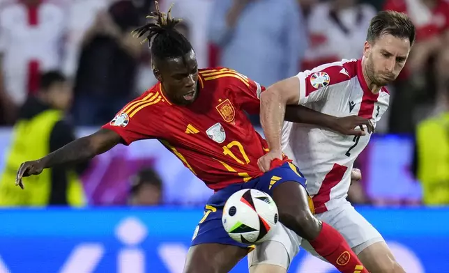 Georgia's Otar Kakabadze, right, challenges Spain's Nico Williams during a round of sixteen match between Spain and Georgia at the Euro 2024 soccer tournament in Cologne, Germany, Sunday, June 30, 2024. (AP Photo/Manu Fernandez)