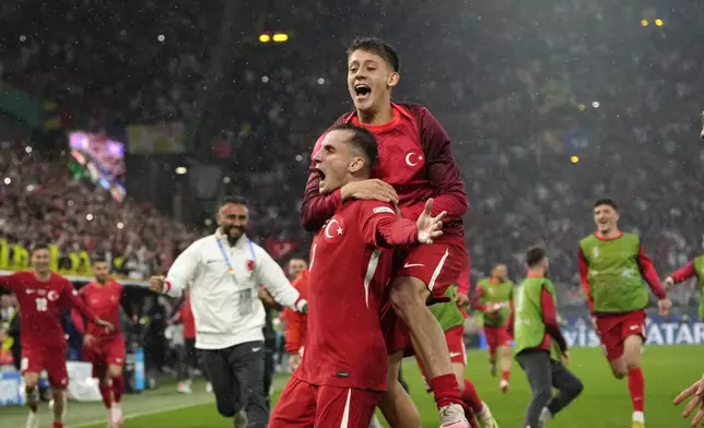 Turkey's Kerem Akturkoglu, bottom, celebrates with his teammate Arda Guler after scoring his side's third goal during a Group F match between Turkey and Georgia at the Euro 2024 soccer tournament in Dortmund, Germany, Tuesday, June 18, 2024. (AP Photo/Alessandra Tarantino)