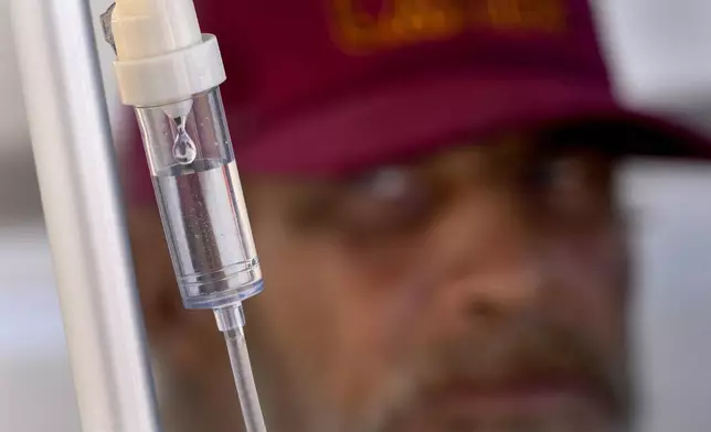 Alfred Handley watches an intravenous saline solution drip administered by the Circle The City medical team, Thursday, May 30, 2024 in Phoenix. Based in the hottest big metro in America, Circle the City is taking measures to protect patients from life-threatening heat illness as temperatures hit new highs. Homeless people accounted for nearly half of the record 645 heat-related deaths last year in Arizona's Maricopa County, which encompasses metro Phoenix.(AP Photo/Matt York)