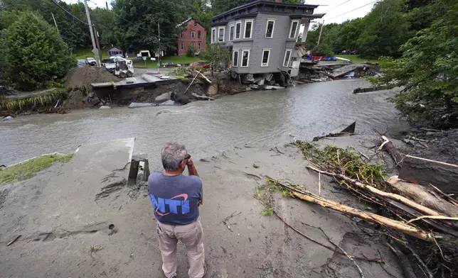 Rick Gordon, of Plainfield, Vt. looks at what remains of Mill Street and an apartment building after remnants of Hurricane Beryl caused flooding and destruction, Friday, July 12, 2024, in Plainfield. (AP Photo/Charles Krupa)