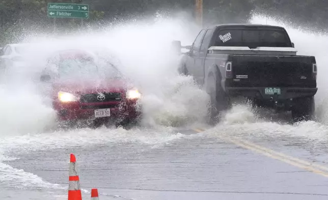 Vehicles drive through high water from the Lamoille River covering Route 15 after remnants of Hurricane Beryl caused flooding, Thursday, July 11, 2024, in Cambridge, Vt. (AP Photo/Charles Krupa)