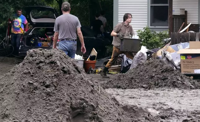 Walker Blackwell, right, cleans up the damage to his home after remnants of Hurricane Beryl caused flooding and destruction, Friday, July 12, 2024, in Plainfield, Vt. (AP Photo/Charles Krupa)