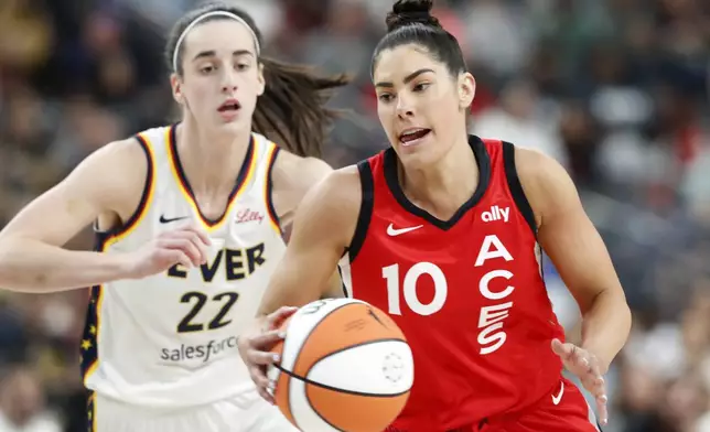 Las Vegas Aces guard Kelsey Plum (10) takes the ball past Indiana Fever guard Caitlin Clark (22) during the first half of an WNBA basketball game Tuesday, July 2, 2024, in Las Vegas. (Steve Marcus/Las Vegas Sun via AP)