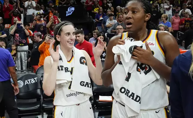 Indiana Fever guard Caitlin Clark, left, celebrates a win over the Phoenix Mercury with Fever forward Aliyah Boston, right, after a WNBA basketball game Sunday, June 30, 2024, in Phoenix. (AP Photo/Ross D. Franklin)