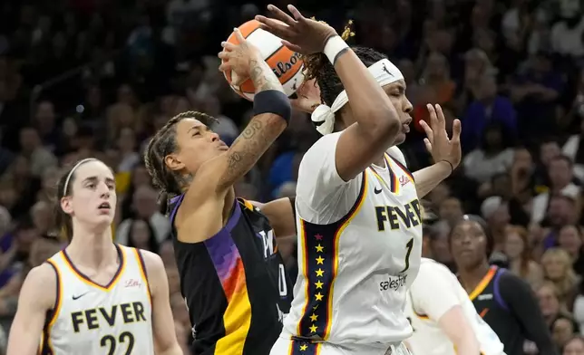 Phoenix Mercury guard Natasha Cloud, center, is fouled by Indiana Fever forward NaLyssa Smith (1) as Fever guard Caitlin Clark (22) looks on during the second half of a WNBA basketball game Sunday, June 30, 2024, in Phoenix. (AP Photo/Ross D. Franklin)