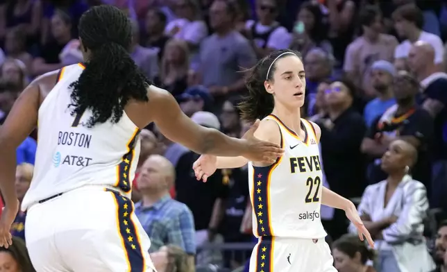 Indiana Fever guard Caitlin Clark (22) slaps hands with Fever forward Aliyah Boston, left, after a assisting against the Phoenix Mercury during the second half of a WNBA basketball game Sunday, June 30, 2024, in Phoenix. (AP Photo/Ross D. Franklin)
