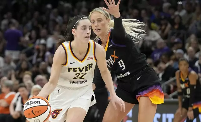 Indiana Fever guard Caitlin Clark (22) dribbles past Phoenix Mercury guard Sophie Cunningham (9) during the first half of a WNBA basketball game Sunday, June 30, 2024, in Phoenix. (AP Photo/Ross D. Franklin)