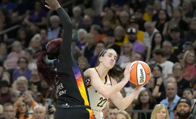 Indiana Fever guard Caitlin Clark (22) goes up to shoot against Phoenix Mercury guard Kahleah Copper during the first half of a WNBA basketball game Sunday, June 30, 2024, in Phoenix. (AP Photo/Ross D. Franklin)
