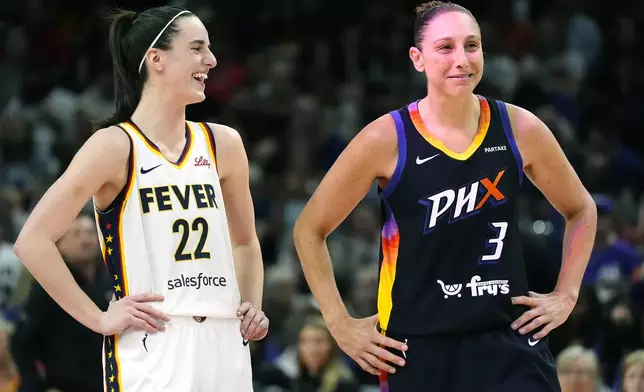 Indiana Fever guard Caitlin Clark (22) and Phoenix Mercury guard Diana Taurasi (3) laugh during the first half of a WNBA basketball game Sunday, June 30, 2024, in Phoenix. (AP Photo/Ross D. Franklin)