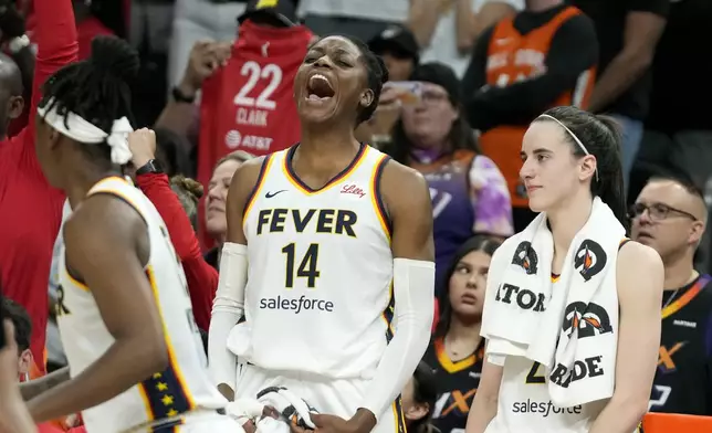 Indiana Fever center Temi Fagbenle (14) celebrates after a win over the Phoenix Mercury while standing next to Fever guard Caitlin Clark, right, in the closing seconds of the second half of a WNBA basketball game Sunday, June 30, 2024, in Phoenix. (AP Photo/Ross D. Franklin)