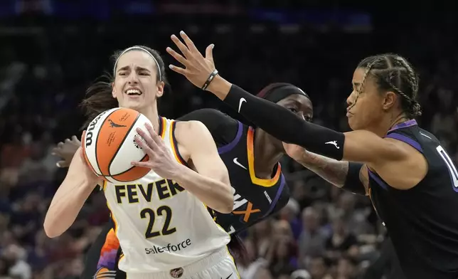Indiana Fever guard Caitlin Clark (22) looks to pass the ball as Phoenix Mercury guard Natasha Cloud (0) defends during the first half of a WNBA basketball game Sunday, June 30, 2024, in Phoenix. (AP Photo/Ross D. Franklin)
