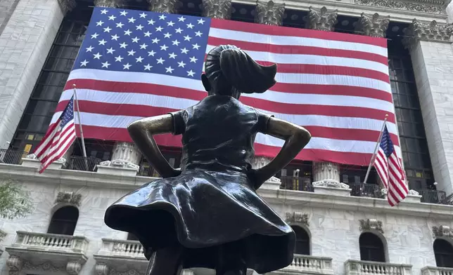 The Fearless Girl statues faces the New York Stock Exchange on July 2, 2024, in New York. Global stocks are mostly lower after benchmarks ended higher on Wall Street. (AP Photo/Peter Morgan)