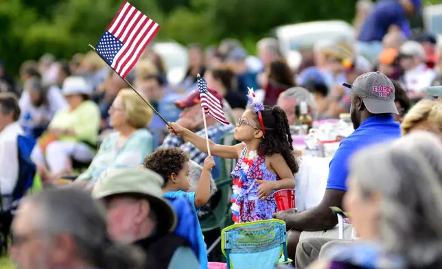 Gabriella Willams, 5, waves an American Flag during the "Symphony of Stars" as part of the 2024 Vermont Symphony Orchestra Summer Festival Tour in Grafton, Vt., Wednesday, July 3, 2024. (Kristopher Radder/The Brattleboro Reformer via AP)