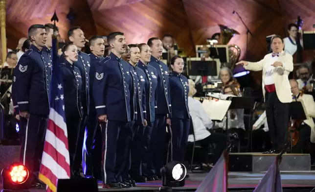 The Singing Sergeants sing the national anthem as Keith Lockhart, right, conducts during the Boston Pops Fireworks Spectacular at the Hatch Memorial Shell on the Esplanade in Boston, Thursday, July 4, 2024. (AP Photo/Michael Dwyer)