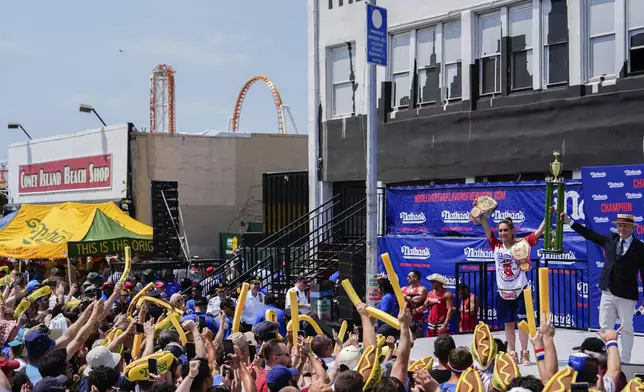 Miki Sudo, right, reacts after winning the women's division in Nathan's Famous Fourth of July hot dog eating contest, Thursday, July 4, 2024, at Coney Island in the Brooklyn borough of New York. Sudo ate a record 51 hot dogs. (AP Photo/Julia Nikhinson)