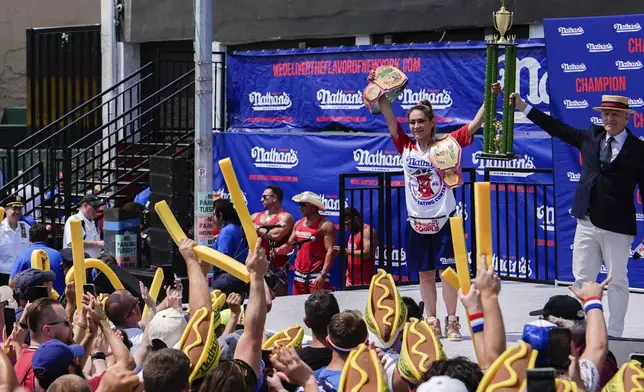 Miki Sudo, second from right, reacts after winning the women's division in Nathan's Famous Fourth of July hot dog eating contest, Thursday, July 4, 2024, at Coney Island in the Brooklyn borough of New York. Sudo ate a record 51 hot dogs. (AP Photo/Julia Nikhinson)