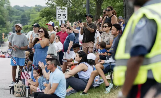 Paradegoers watch the Independence Day Parade along Green Bay Road in Highland Park, Ill., Thursday, July 4, 2024. (Pat Nabong/Chicago Sun-Times via AP)