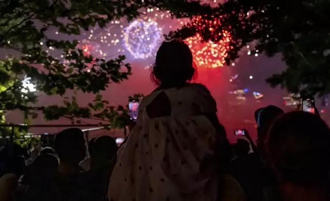 A girl watches Macy's Fourth of July fireworks over New York, Thursday, July 4, 2024, in Hoboken, N.J. (AP Photo/Julia Nikhinson)
