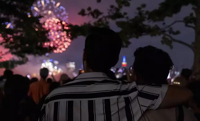 People watch Macy's Fourth of July fireworks over New York, Thursday, July 4, 2024, in Hoboken, N.J. (AP Photo/Julia Nikhinson)