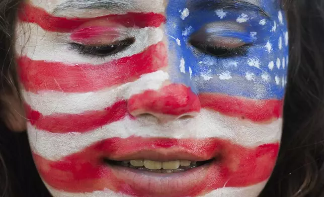 Jessica Mitchell is seen with her faces painted like the American flag during the annual Freedom Over Texas Festival at Eleanor Tinsley Park on the Fourth of July, Thursday, July 4, 2024, in Houston. Mitchell said it took her 45 minutes to complete her patriotic face paint. (Jason Fochtman/Houston Chronicle via AP)
