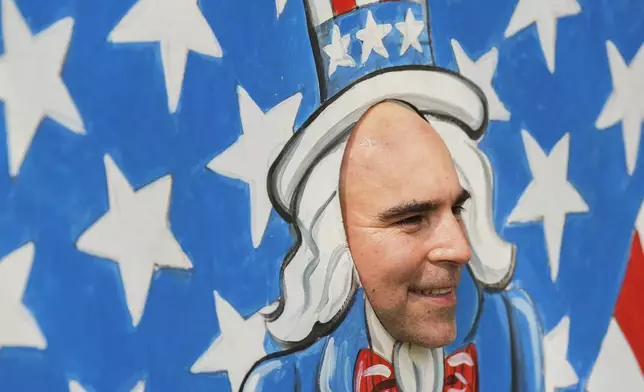 Santiago Meneses takes a photo through a cutout depicting Uncle Sam during the annual Freedom Over Texas Festival at Eleanor Tinsley Park on the Fourth of July, Thursday, July 4, 2024, in Houston. (Jason Fochtman/Houston Chronicle via AP)