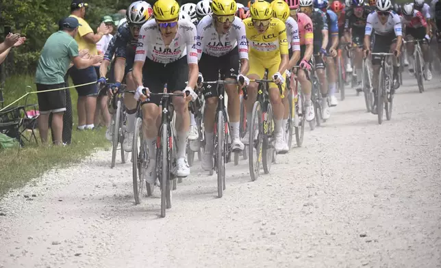 Slovenia's Tadej Pogacar, wearing the overall leader's yellow jersey, follows his teammates on a gravel road during the ninth stage of the Tour de France cycling race over 199 kilometers (123.7 miles) with start and finish in Troyes, France, Sunday, July 7, 2024. (Bernard Papon/Pool Photo via AP)